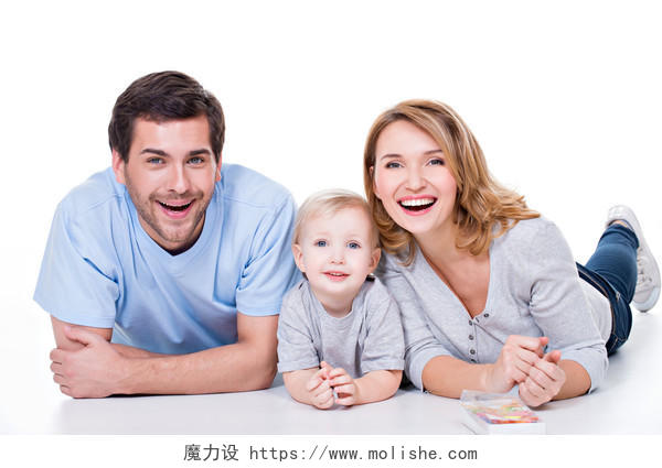 微笑年轻父母和孩子躺在地上的白色背景上孤立在一起的照片